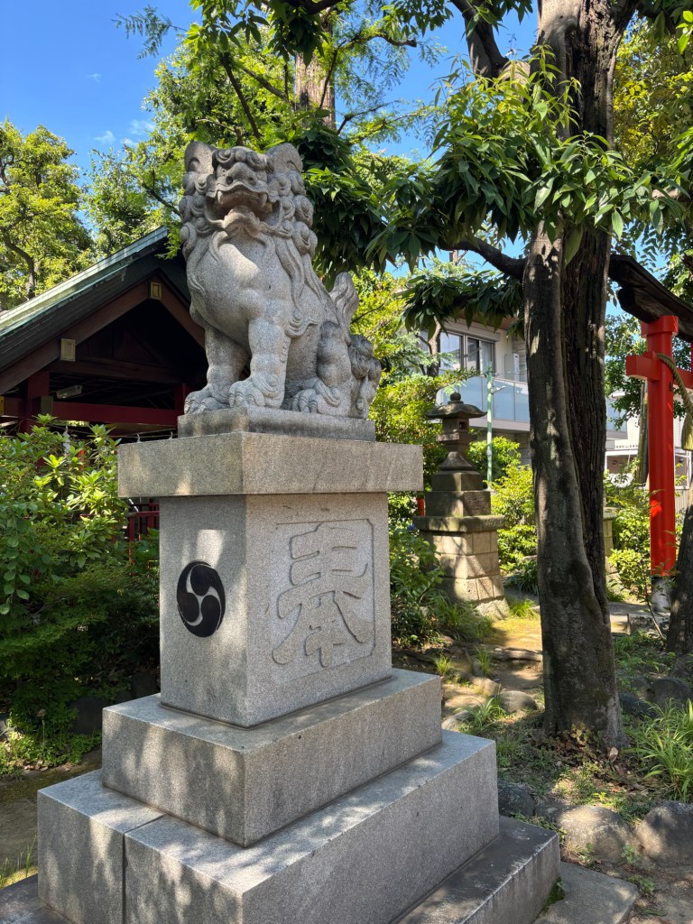 A komainu or fu-dog with its mouth open ("a"), symbolizing the beginning of all things.